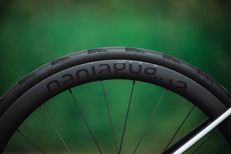 closeup detail of parcours paniagua budget carbon aero road bike wheels on a bike